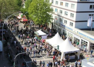 Besucher auf einem Straßenfest mit Pavillons und einer Bühne
