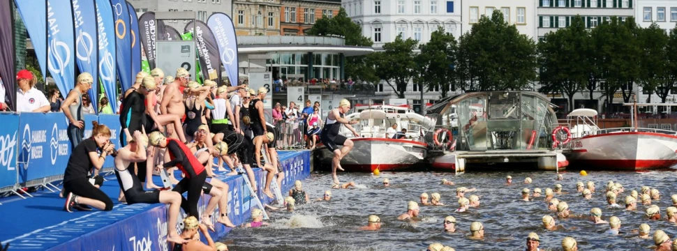 Teilnehmer klettern beim Hamburg Wasser Triathlon aus der Alster