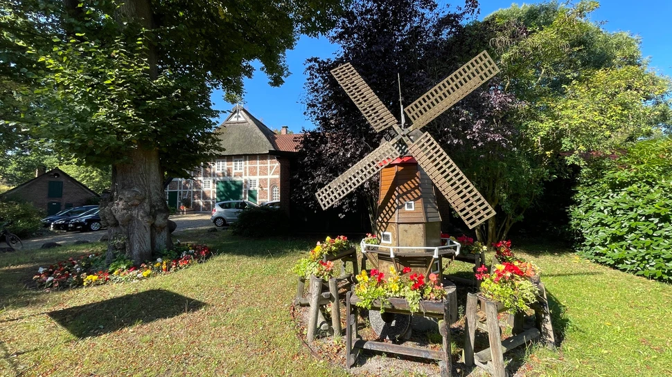 kleine Mühle vor einem Fachwerkhaus