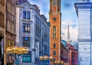 Hamburger Alte Post mit Backsteinturm und Uhr, umgeben von historischen Gebäuden und modernen Straßenlaternen