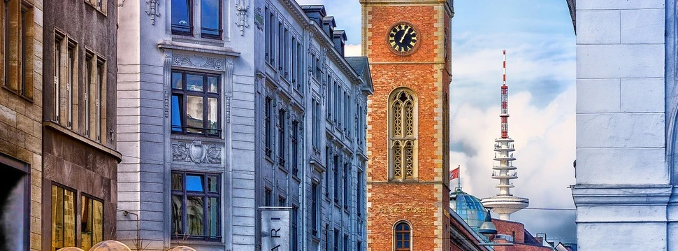 Hamburger Alte Post mit Backsteinturm und Uhr, umgeben von historischen Gebäuden und modernen Straßenlaternen