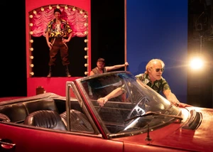 Hamburger Theaterfestival: Die schmutzigen Hände Mann mit Sonnenbrille steht hinter einem Cabrio auf einer Theaterbühne