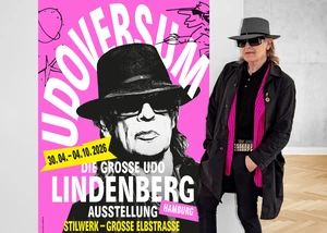 Udo Lindenberg im Udoversum vor einem Ausstellungsplakat
