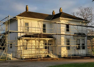 Ein weißes Wohnhaus mit einem Baugerüst