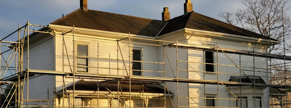 Ein weißes Wohnhaus mit einem Baugerüst