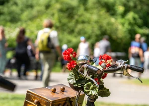 Im Vordergrund steht ein Fahrrad, dahinter laufen Menschen