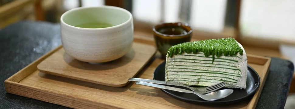 Matcha-Crêpe-Kuchen mit Genmaicha Uji Latte in der japanischen Keramikschale