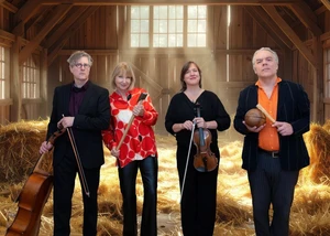 Sabine Kaack mit den Mitgliedern von United Baroque stehen mit Instrumenten in einer Scheune