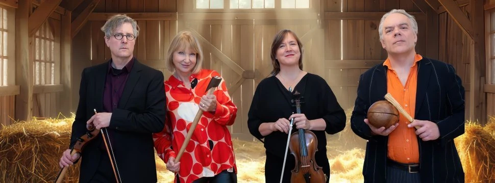 Sabine Kaack mit den Mitgliedern von United Baroque stehen mit Instrumenten in einer Scheune