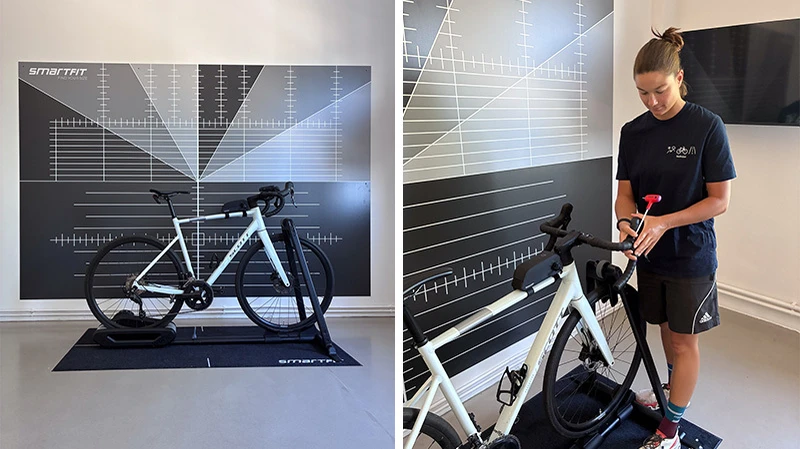 Weißes Rennrad vor Smartfit-Wand und Laborleiterin Sera Satzky beim Einstellen eines Lenkers am Rennrad
