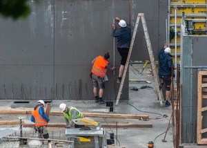 Bauarbeiter arbeiten auf einer Baustelle an einem Haus