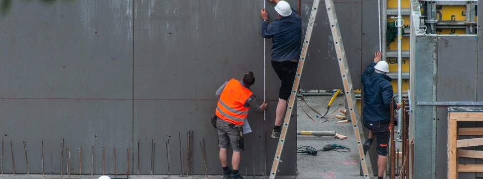 Bauarbeiter arbeiten auf einer Baustelle an einem Haus
