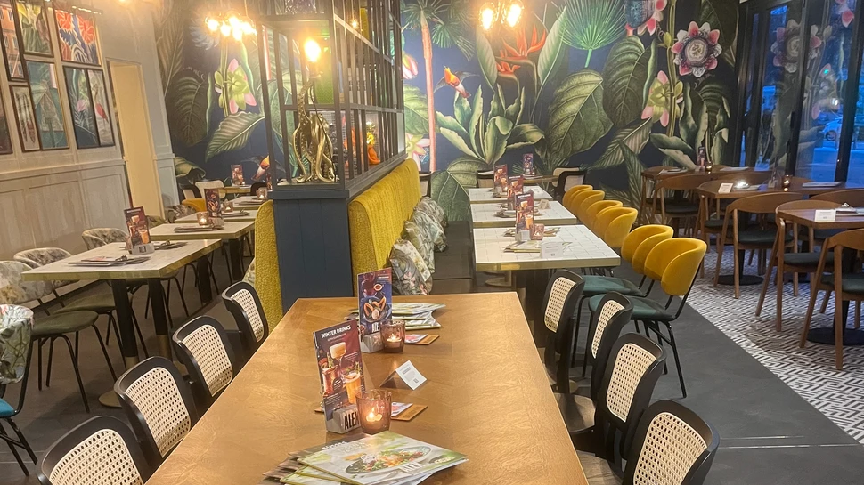 Tische und bunte Wanddekoration im ALEX Hamburg am Rothenbaum