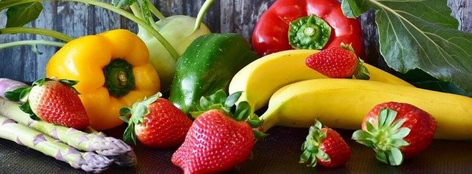 Die richtige Ernährung ist wichtig für die Gesundheit. verschiedenen Obst- und Gemüsesorten liegen vor einer Holzwand