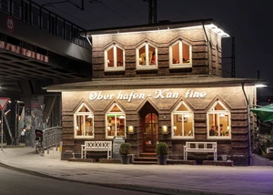 Beleuchtetes Restaurant "Oberhafen-Kantine" mit Klinkerfassade und warmen Fenstern bei Nacht in der Stadt.