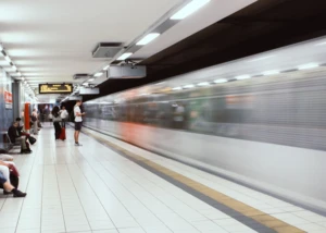 Personen auf einem Bahnsteig und vorbeifahrende U-Bahn