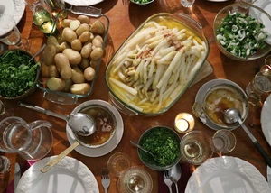 Ein Tisch, reich gedeckt mit Spargel, Kartoffeln und Salat