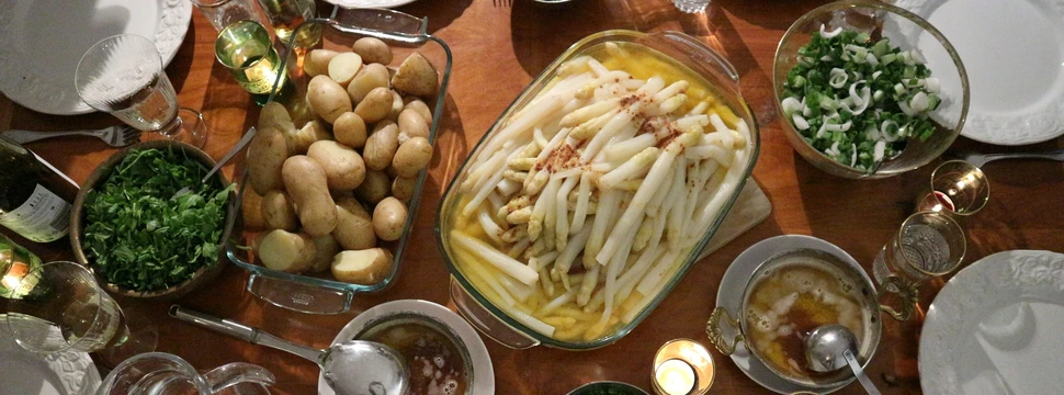Ein Tisch, reich gedeckt mit Spargel, Kartoffeln und Salat