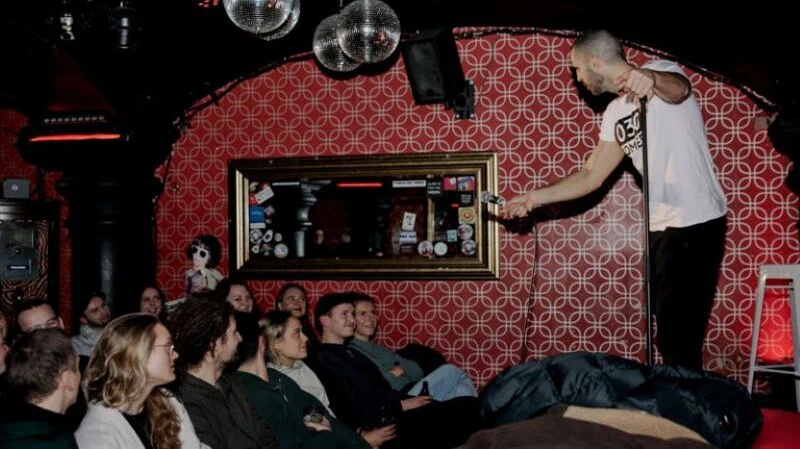 Männlicher Comedian in Interaktion von der Bühne mit dem Publikum