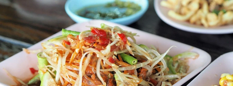 Thailändischer Papaya Salat und thailändisches Essen in Schüsseln