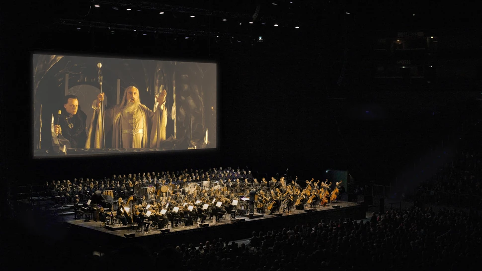 Große Kinoleinwand vor der ein großes Orchester aufgestellt ist
