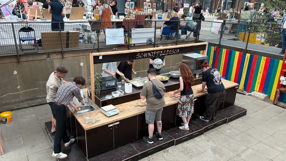 Kochstation "Schnippeldisco" umringt von Menschen, die kochen