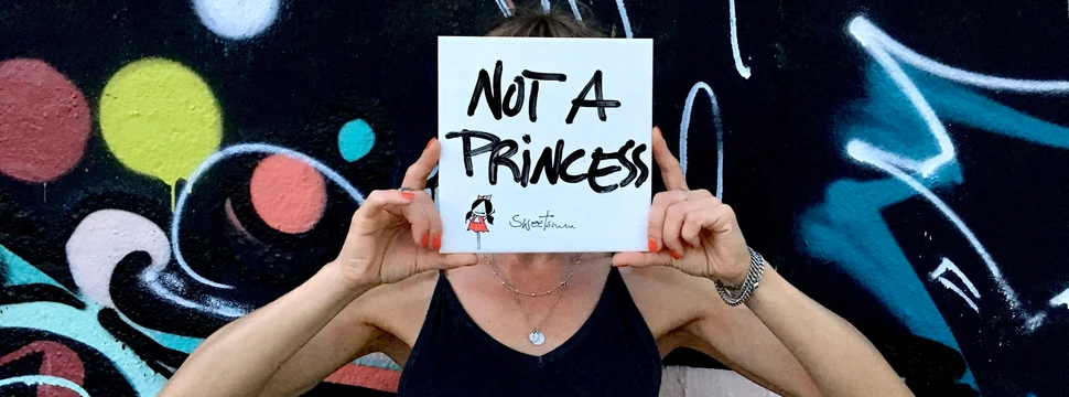 Künstlerin Sweetnini versteckt ihren Kopf hinter einer Fliese mit der Aufschrift "Not a Princess"