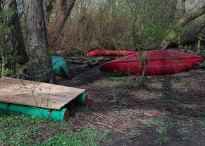 Selbstgebaute Flöße, Kanus und Boote am Ufer abgeladen