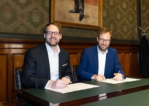 zwei Männer im blauen Anzug unterschreiben einen Vertrag