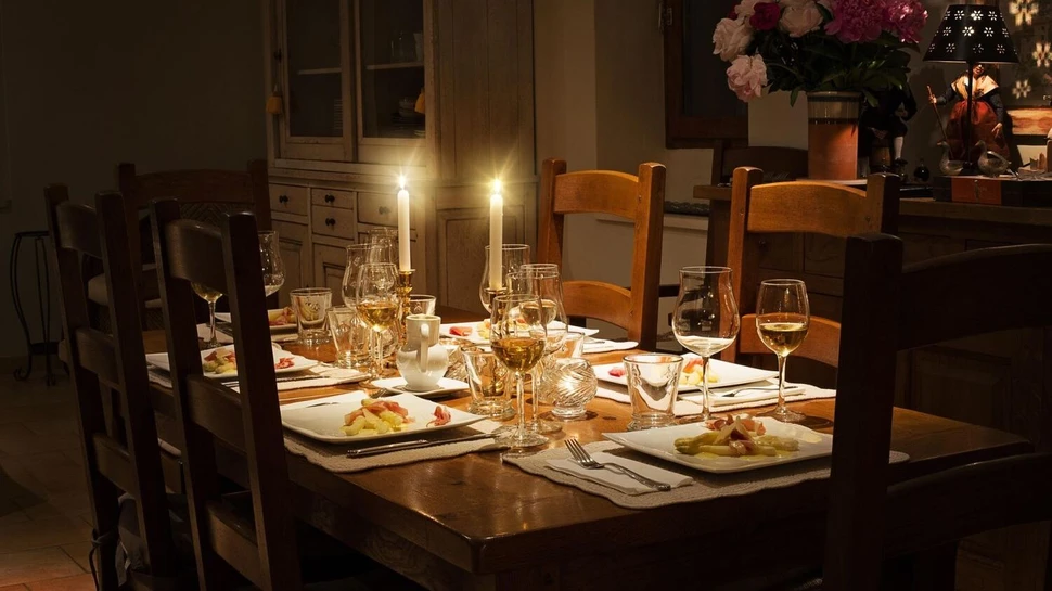 Gedeckter Tisch mit gefüllten Teller, Weingläsern und Kerzen