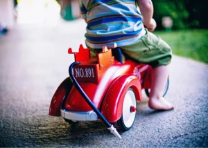 Kinder-Fahrzeug Kleines Kind auf einem Kinder-Fahrzeug