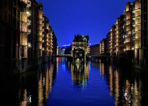 Die Speicherstadt mit dem Wasserschloss und mit Spiegelung des blauen Lichtes beim Blueport Hamburg