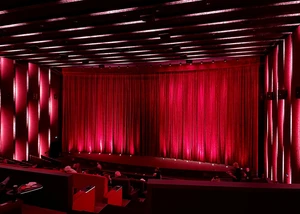 Kinosaal mit rotem Vorhang vor der Leinwand
