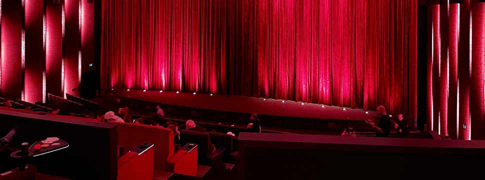 Kinosaal mit rotem Vorhang vor der Leinwand