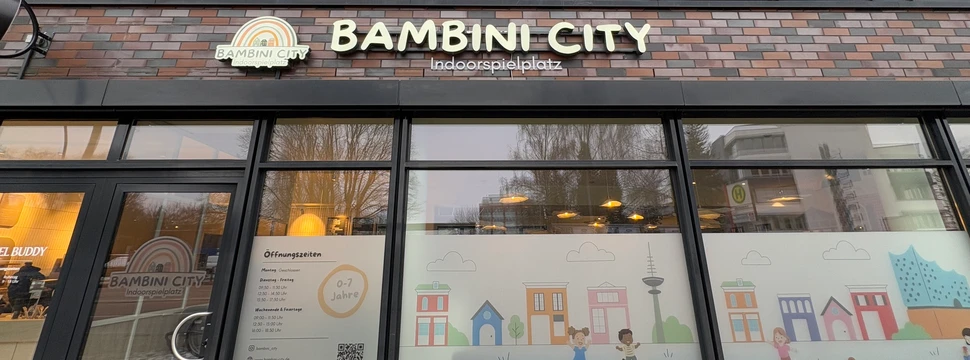 Außenansicht des Indoor‑Spielplatzes Bambini City mit Eingang und Beschilderung.