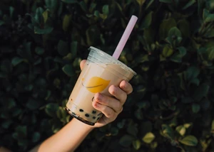 Eine Hand, die einen Becher Bubble Tea in die Kamera hält