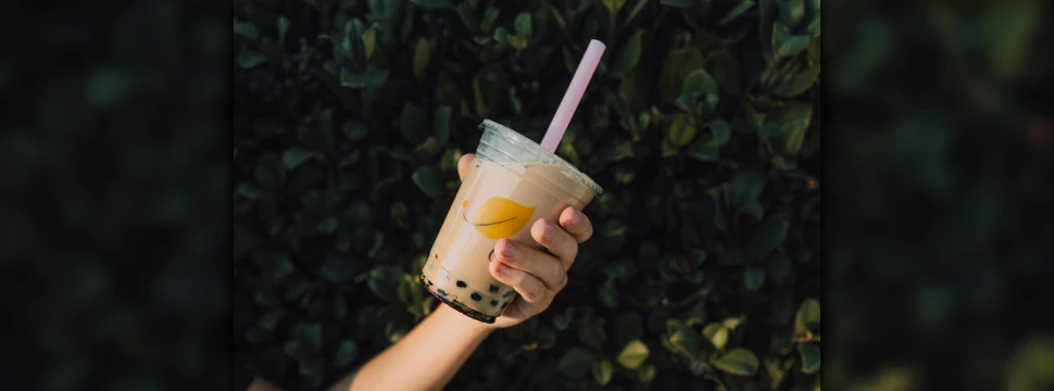 Eine Hand, die einen Becher Bubble Tea in die Kamera hält