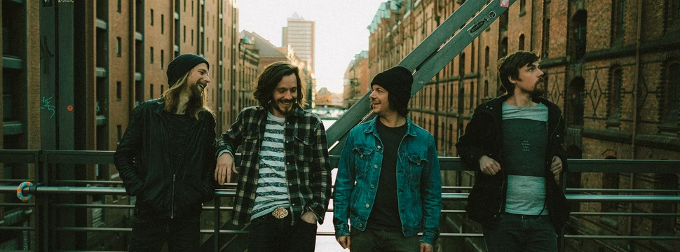 Die 4 Mitglieder der Hamburger BandDenManTau posieren auf einer Brücke in der Hamburger Speicherstadt