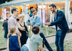 Ein Zauberer beim Aufführen von Tricks mit mehreren zuschauenden Menschen