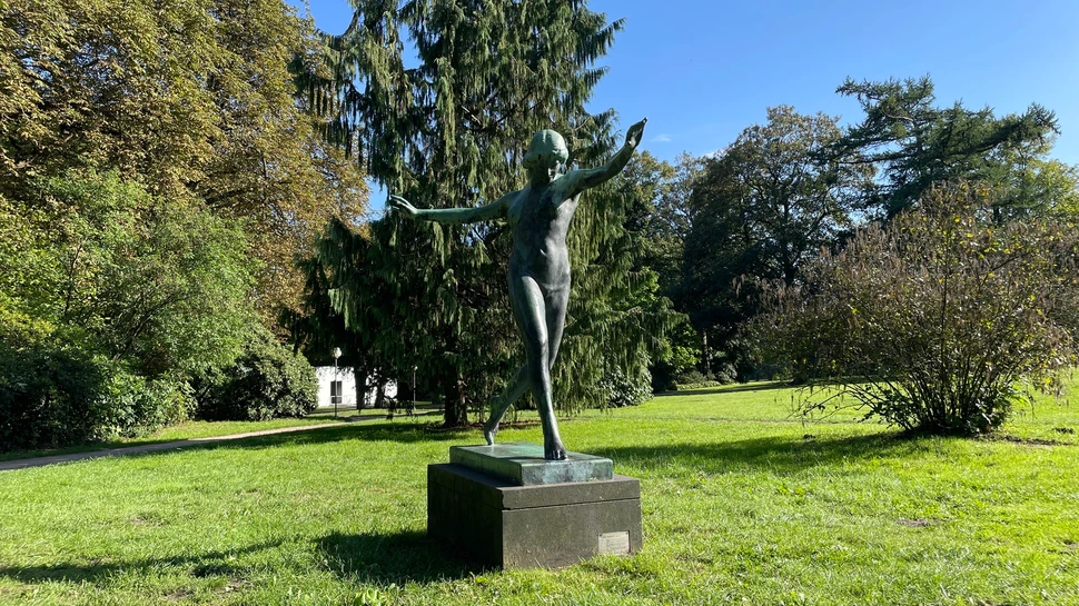 tanzende Bronzefigur in einem Park