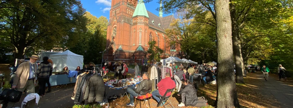 Aufgebaute Stände beim Flohmarkt Immenhof vor der alten Backsteinkirche St. Gertrud