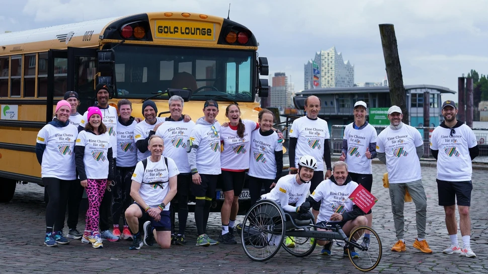 Sportler und Parasportler beim Run for Olympia vor einem Bus mit der Elphi im Hintergrund