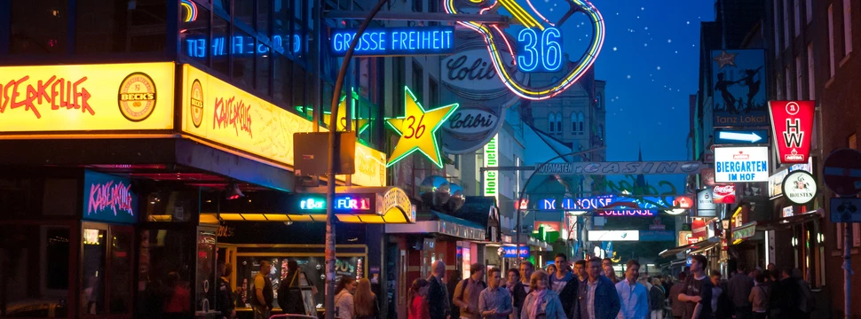 Blick in die Straße Große Freiheit auf der Reeperbahn mit Leuchtreklame und vielen Menschen