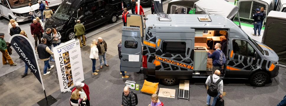 Camper stehen in einem Messeraum