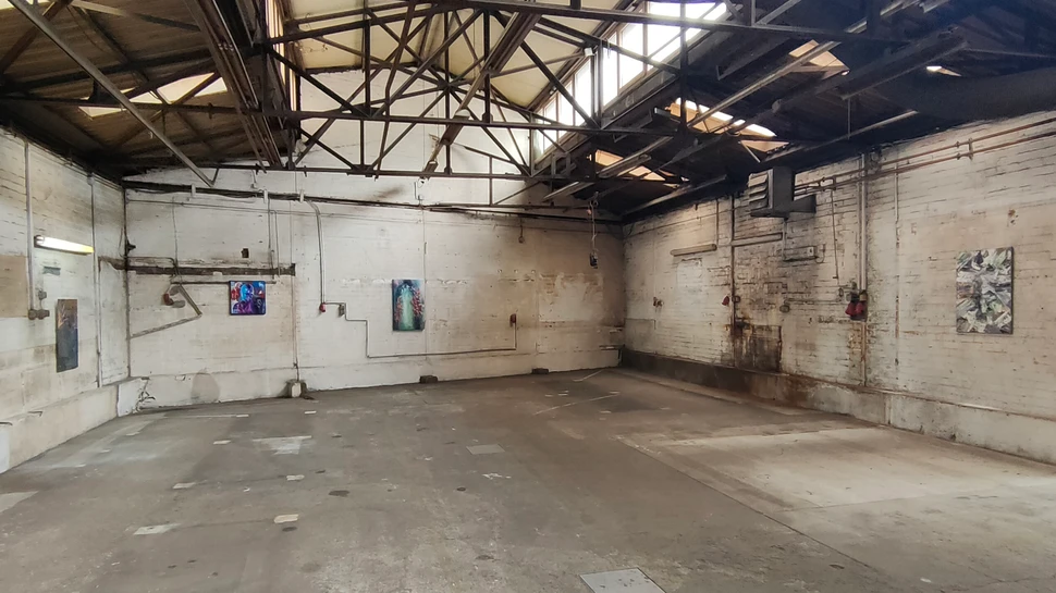 Pop-up Ausstellung Industrial Heartbeats in einer stillgelegten Schlosserei Bilder in verschiedenen Größen hängen an den Wänden einer Fabrik