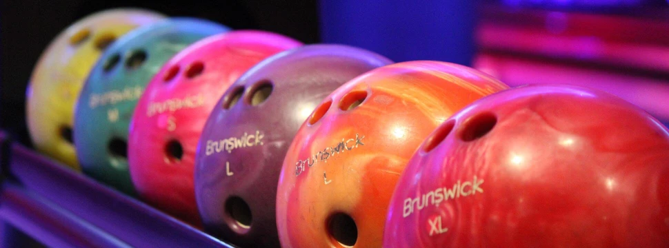 Bowlingkungeln 6 unterschiedlich farbige Bowlingkugeln liegen auf der Ablage
