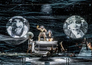 Schauspieler auf einer Bühne mit Projektionen