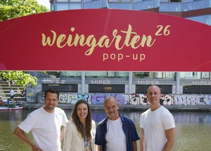 vier Personen vor einem roten Schild mit der Aufschrift Weingarten 26 Pop-up