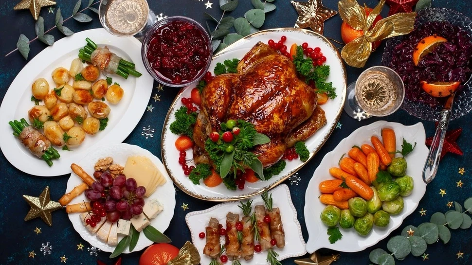 Weihnachtlich gedeckter Tisch mit Gänsebraten und Beilagen