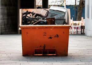 Oranger Container mit Sperrmüll drin.